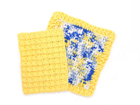 Handmade crocheted dishcloths in sunshine yellow, blues, and white